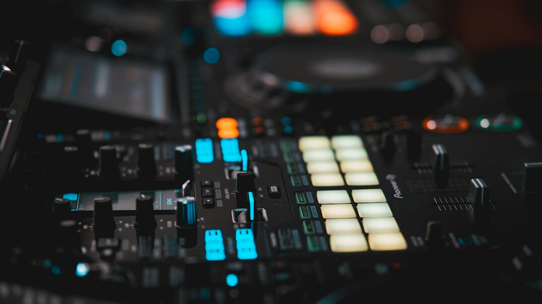 Audio mixing desk with glowing faders and lights